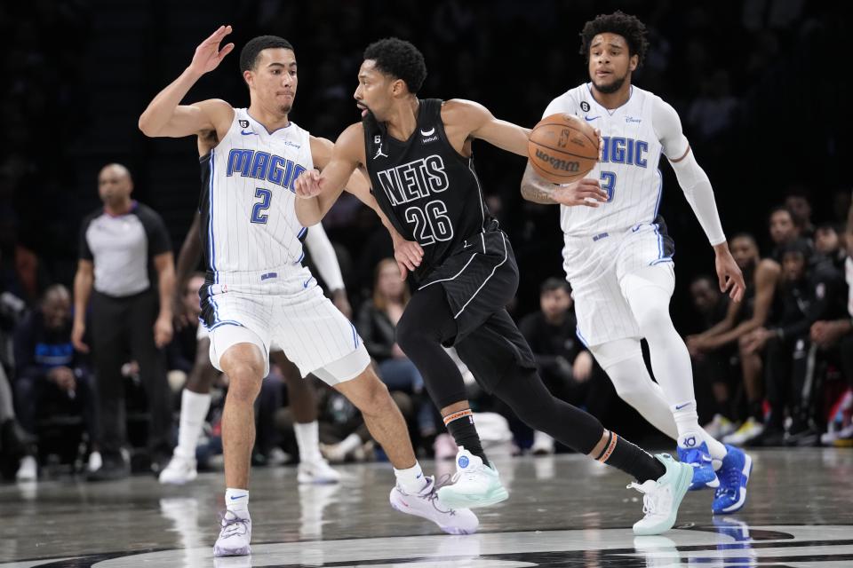 Brooklyn Nets guard Spencer Dinwiddie (26) drives to the basket against Orlando Magic guard Caleb Houstan (2) and forward Chuma Okeke during the first half of an NBA basketball game Friday, April 7, 2023, in New York. (AP Photo/Mary Altaffer)