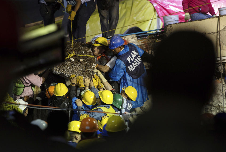 <p>Search and rescue team members work to bring down a large piece of concrete during rescue efforts at the Enrique Rebsamen school in Mexico City, Mexico, Thursday, Sept. 21, 2017, in an effort to reach a young girl buried in the rubble of the school. (AP Photo/Anthony Vazquez) </p>