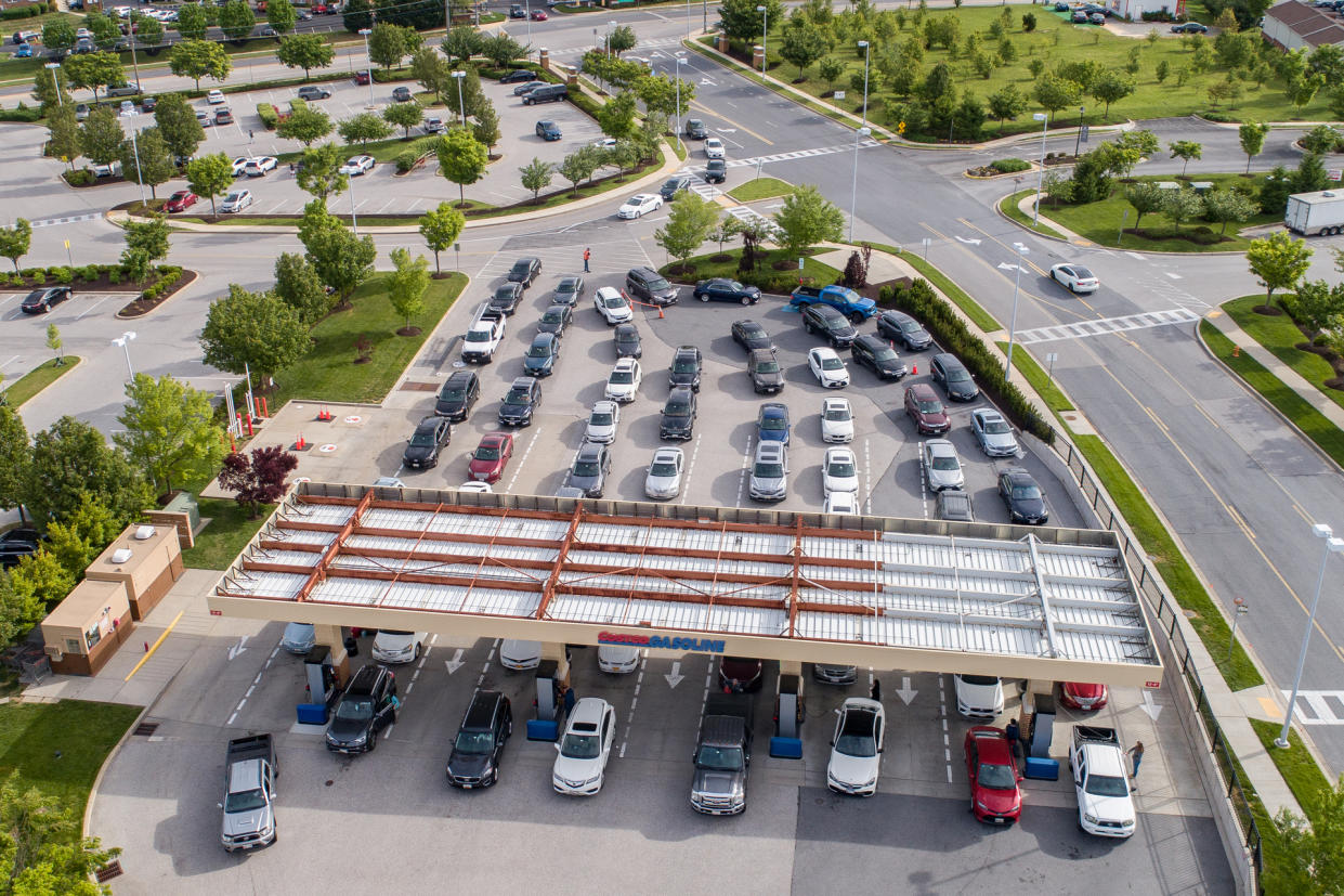 Aerial high-angle view of cars lined up for gas in the morning at a gas station during the perceived gas shortage.