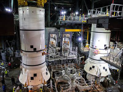 In the Vehicle Assembly Building (VAB) at NASA’s Kennedy Space Center in Florida, workers help secure the second of two Artemis I aft booster segments for the Space Launch System onto the mobile launcher in High Bay 3 on Nov. 24, 2020. In view at right are the first aft booster segments secured on the mobile launcher. Workers with Exploration Ground Systems and contractor Jacobs teams will stack the twin five-segment boosters on the mobile launcher over a number of weeks. When the core stage arrives, it will join the boosters on the mobile launcher, followed by the interim cryogenic propulsion stage and Orion spacecraft. Manufactured by Northrop Grumman in Utah, the twin boosters provide more than 75 percent of the total SLS thrust at launch. The SLS is managed by Marshall Space Flight Center in Huntsville, Alabama. Under the Artemis program, NASA will land the first woman and the next man on the Moon by 2024. The first in a series of increasingly complex missions, Artemis I will test the Orion spacecraft and SLS as an integrated system ahead of crewed flights to the Moon. 