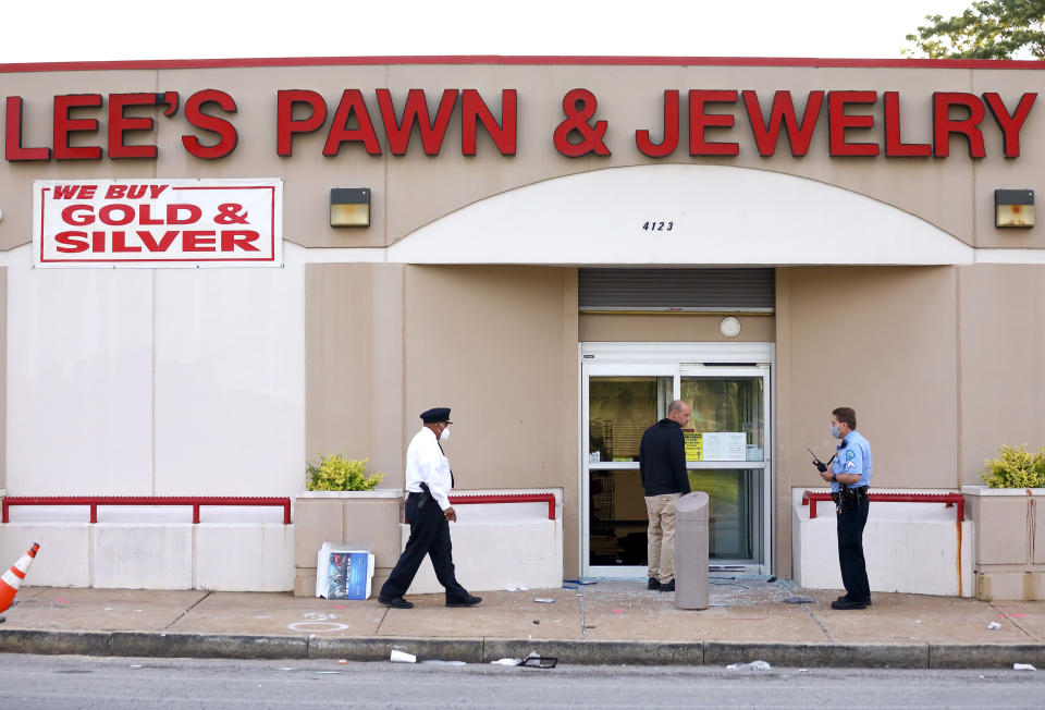 Police investigate the scene of a shooting at Lee's Pawn & Jewelry in St. Louis, Tuesday, June 2, 2020. A 77-year-old retired St. Louis police officer who served 38 years on the force was shot and killed by looters at the pawn shop early Tuesday, police said. David Dorn was found dead on the sidewalk in front of Lee's Pawn & Jewelry, which had been ransacked after peaceful protests over the death of George Floyd turned violent overnight. (David Carson/St. Louis Post-Dispatch via AP)