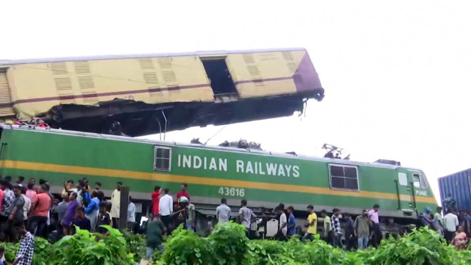 People gather around the wreckage of a train after a collision in West Bengal, India on June 17, 2024. - ANI/Reuters