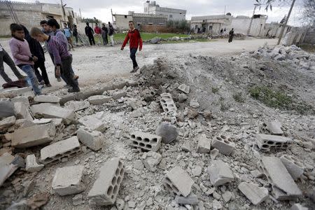 Residents inspect damaged ground after a shell fell in the rebel held town of Jarjanaz, southern Idlib countryside, Syria March 5, 2016. REUTERS/Khalil Ashawi