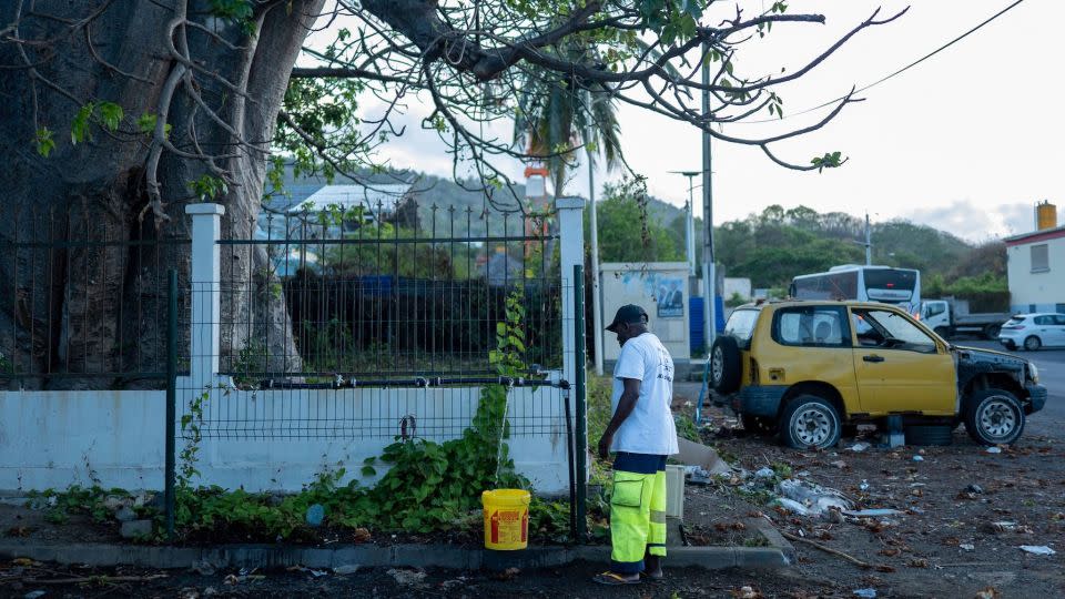 A man fills a bucket with water in Dzaoudzi, on the French Indian Ocean island of Mayotte, Nov. 7, 2023. - Marion Joly/AFP/Getty Images