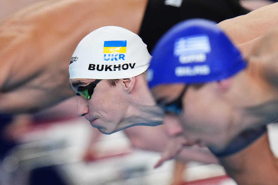 Vladyslav Bukhov of Ukraine, left, competes in the men's 50-meter freestyle heat at the World Aquatics Championships in Doha, Qatar, Friday, Feb. 16, 2024. (AP Photo/Hassan Ammar)