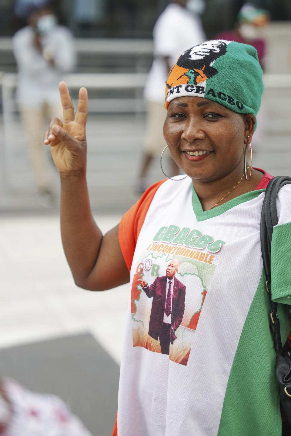 A supporter of former Ivory Coast President Laurent Gbagbo gestures as she gathers with others at the Brussels international airport in Brussels, Thursday, June 17, 2021. The former Ivory Coast president Laurent Gbagbo is returning home to Ivory Coast for the first time in nearly a decade, after his acquittal on war crimes charges was upheld at the International Criminal Court earlier this year. (AP Photo/Olivier Matthys)