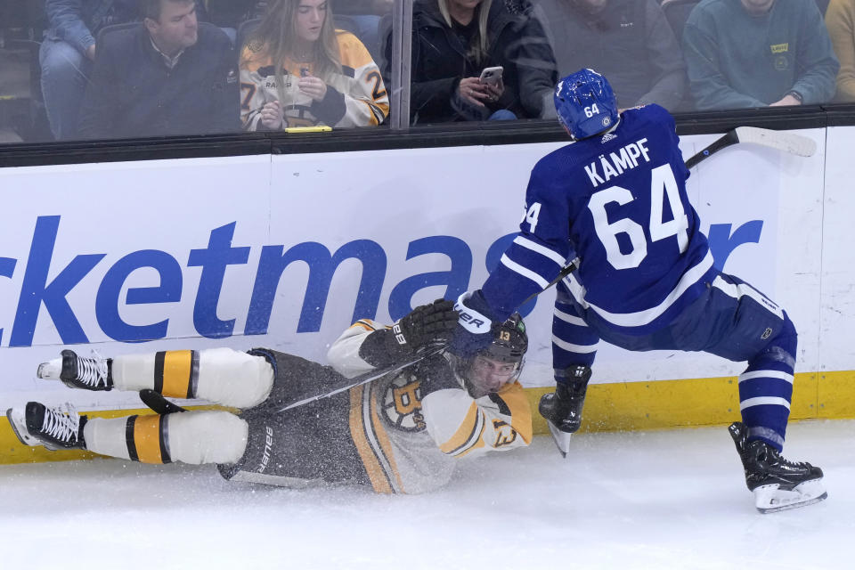 Boston Bruins center Charlie Coyle (13) crashes to the ice after colliding with Toronto Maple Leafs center David Kampf (64) during the first period of an NHL hockey game Thursday, Nov. 2, 2023, in Boston. (AP Photo/Steven Senne)