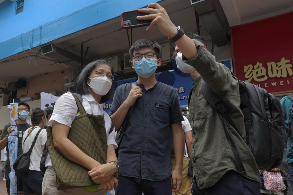 Hong Kong activist Joshua Wong poses for a photo with supporters after attending an activity for the upcoming Legislative Council elections in Hong Kong Saturday, June 20, 2020. Wong said Thursday that opposing a draft national security law for Hong Kong “could be my last testimony (while) I am still free.” (AP Photo/Vincent Yu)