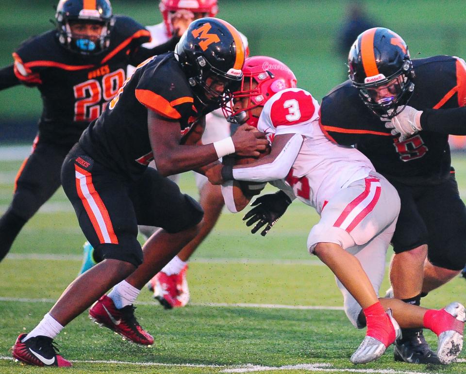 Marlington's Cavail Nicholson, left, and Koby Vance tackle Youngstown Chaney's Bryson Douglas, Friday Sept. 8, 2023.