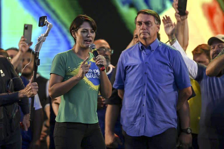 El ex presidente brasileño Jair Bolsonaro escucha a la ex primera dama Michelle Bolsonaro hablar durante el evento Marcha por Jesucristo en Río de Janeiro, Brasil, el 13 de agosto de 2022.