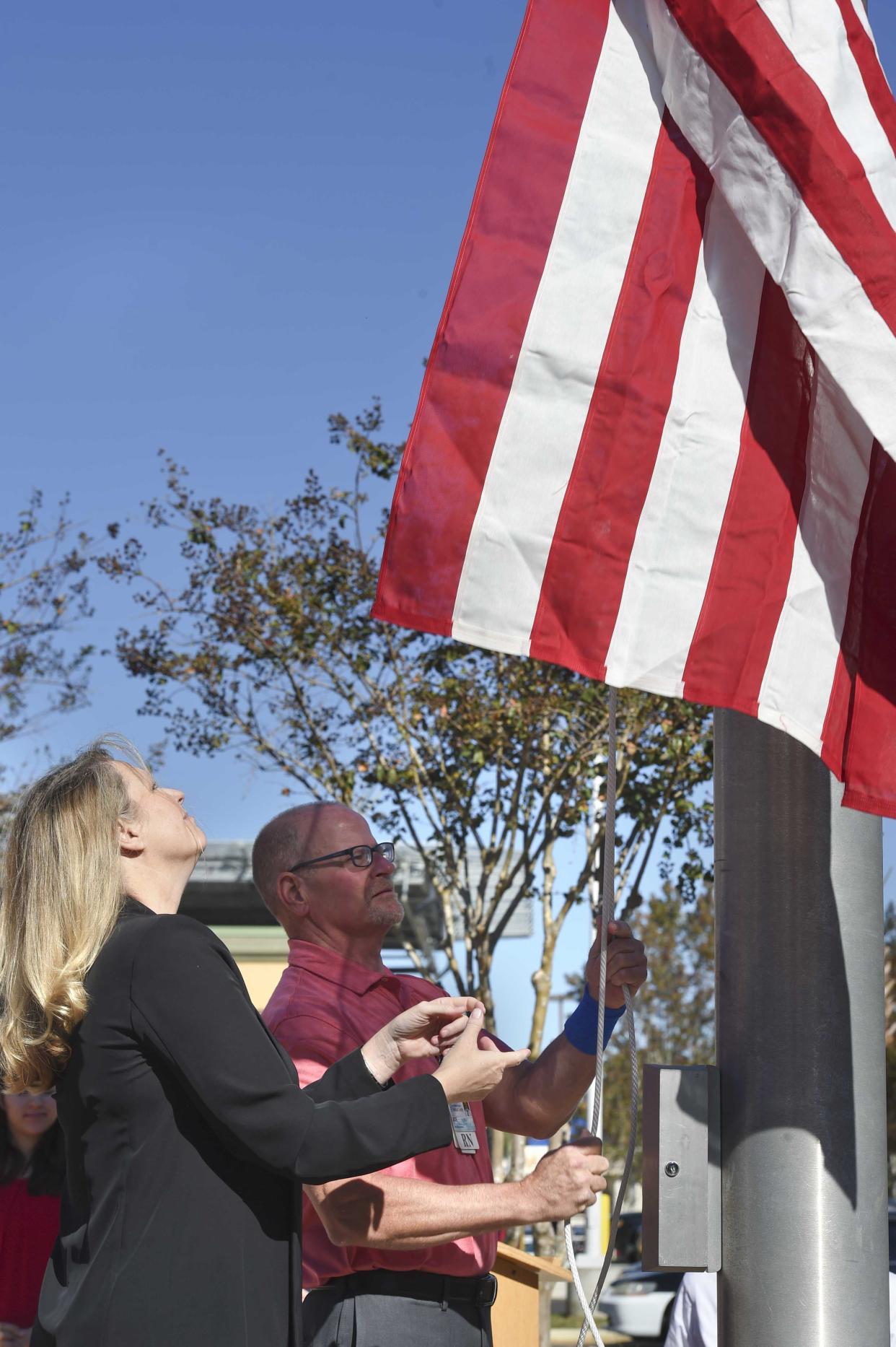 Veterans Kelly Jordan and Joe Tarro raise the American flag during a Veterans Day cerermony at the Fort Walton Beach Medical Center.