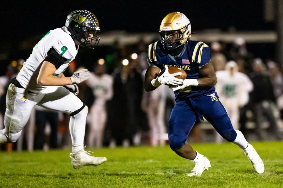 New Prairie's Noah Mungia (2) runs as Northridge’s Conner Roth (9) goes for a tackle during the New Prairie vs. Northridge regional championship football game Friday, Nov. 11, 2022 at New Prairie High School in New Carlisle.