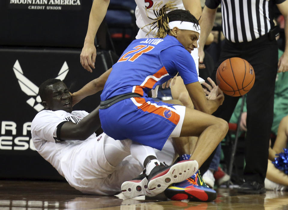 Boise State's Derrick Alston (21) and San Diego State's Aguek Arop (3) become entangled during the second half of an NCAA college basketball game in the Mountain West Conference men's tournament Friday, March 6, 2020, in Las Vegas. (AP Photo/Isaac Brekken)