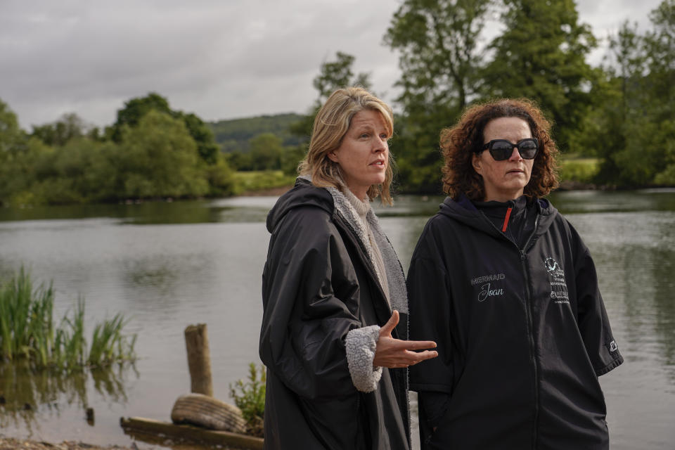 Endurance Swimmers Joan Fennelly, right, and Jo Robb, members of the open water swimming group Henley Mermaids, speak during an interview with The Associated Press, in Henley-on-Thames, England, Friday, June 14, 2024. Fennelly and Robb are undaunted by frigid water and long distances, swimming year-round in the wild. But they takes extra precautions in their own backyard. The River Thames is one of Britain's many waterways contaminated with sewage and agricultural pollution. (AP Photo/Alberto Pezzali)