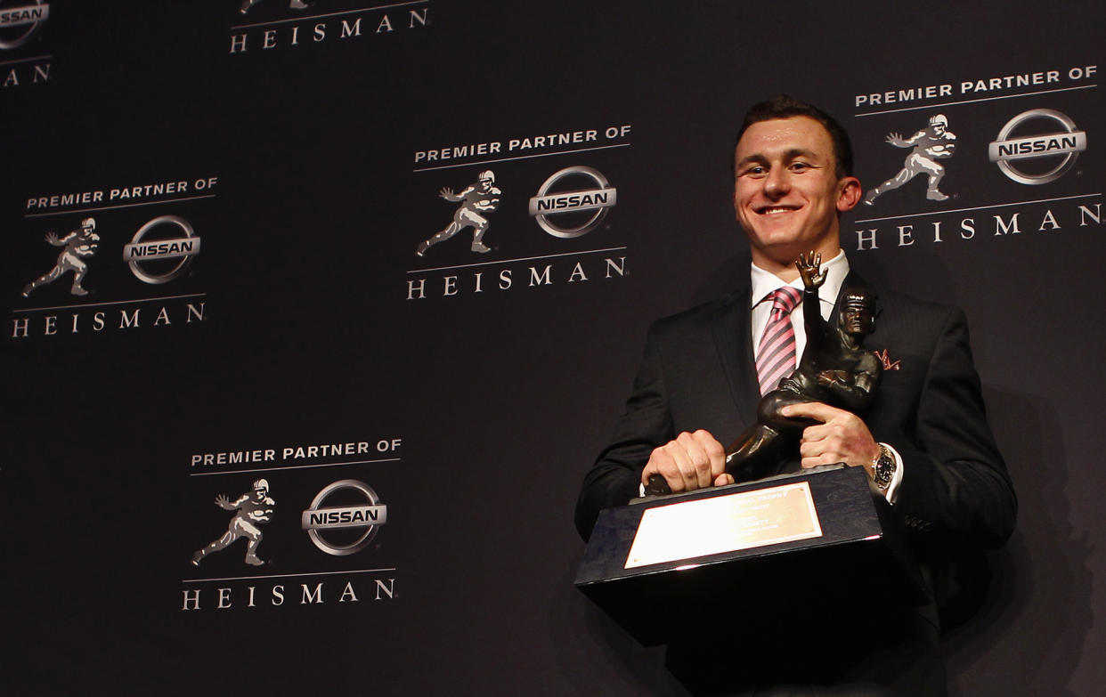 Texas A&M quarterback Johnny Manziel holds the Heisman Trophy during a news conference after winning the award in New York December 8, 2012. Manziel was awarded the Heisman Trophy on Saturday, making him the first 'freshman' to win college football's top honour. REUTERS/Adam Hunger (UNITED STATES - Tags: SPORT FOOTBALL)