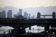 Canary Wharf can be seen in the distance as a person walks along a footbridge, amid the coronavirus disease (COVID-19) outbreak, in London