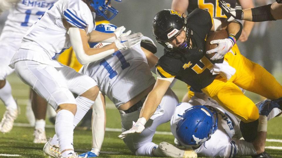 Bishop Kelly senior running back Peter Minnaert, right, fights for extra yards in the first quarter of a 4A state quarterfinal against Emmett on Friday. Minnaert ran for 175 yards and two touchdowns to lead the Knights to a 28-7 win. Sarah A. Miller/smiller@idahostatesman.com