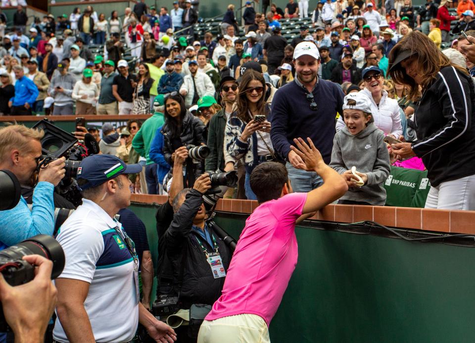 Carlos Alcaraz of Spain gives his match-worn wristband to a young fan after winning the men's singles final at the BNP Paribas Open of the Indian Wells Tennis Garden in Indian Wells, Calif., Sunday, March 19, 2023. 