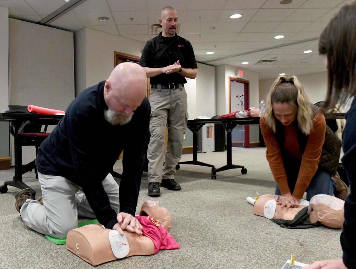 Students Steve Holman of Minerva and Tammy Berg of Dalton work with Randy Feesler, standing, owner of The Pulse Provider, at a lifesaving class at the American Red Cross offices in Canton.