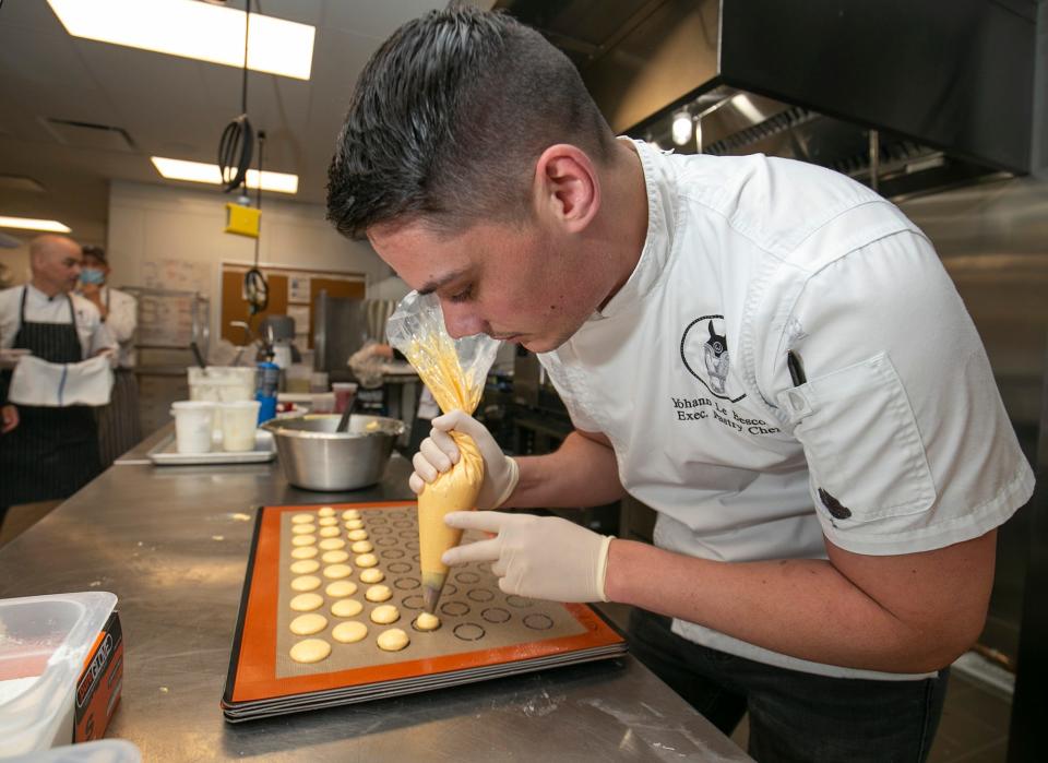 Pastry Chef Yohann Le Bescond, right, makes macaroons in the kitchen of Emma's Patisserie at the World Equestrian Center Thursday May 20.