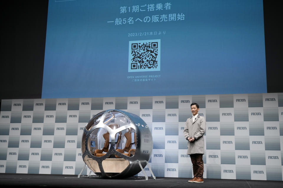 Keisuke Iwaya, CEO of a Japanese space development company, Iwaya Giken, unveils a two-seater cabin and a balloon that the company says is capable of rising to an altitude of 15 miles, which is roughly the middle of the stratosphere, as he speaks during a news conference in Tokyo, Tuesday, Feb. 21, 2023. The Japanese startup company announced plans Tuesday to launch a commercial space viewing balloon flight that it hopes will bring down to earth an otherwise astronomically expensive experience. (AP Photo/Eugene Hoshiko)