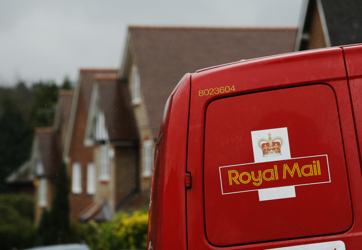 A Royal Mail postal van is parked outside homes