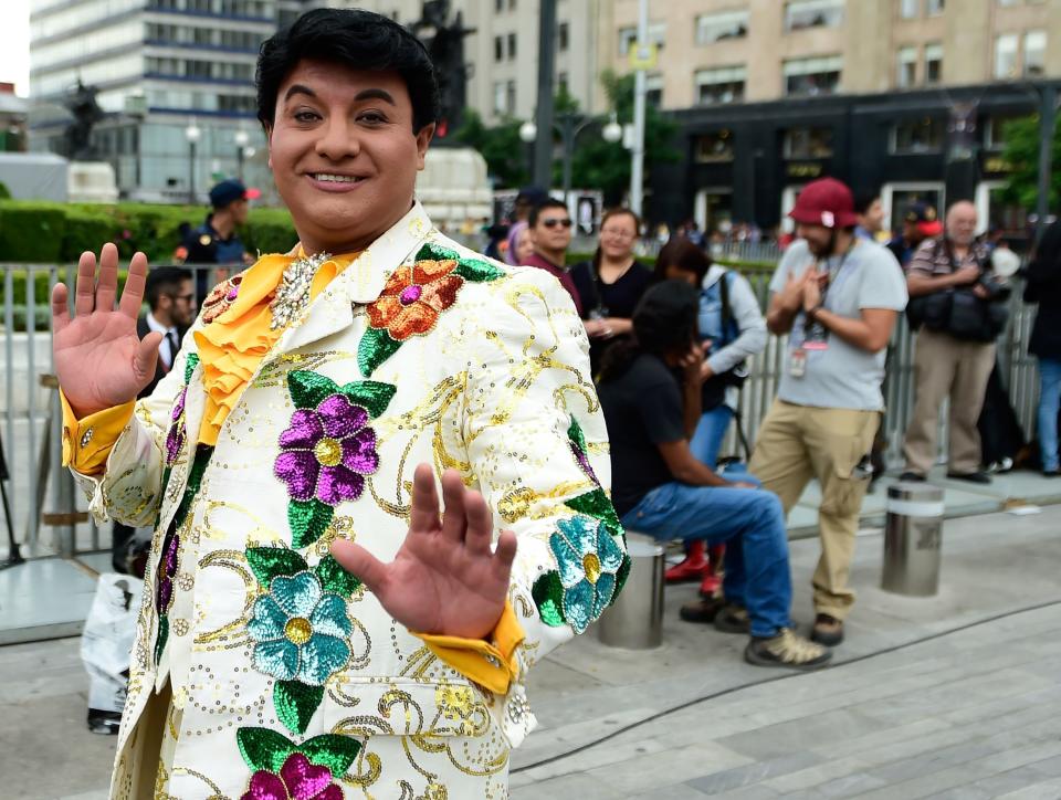 A fan of late Mexican singer song-writer Juan Gabriel --impersonating him-- waits for the arrival of his ashes at the Fine Arts Palace in Mexico City.