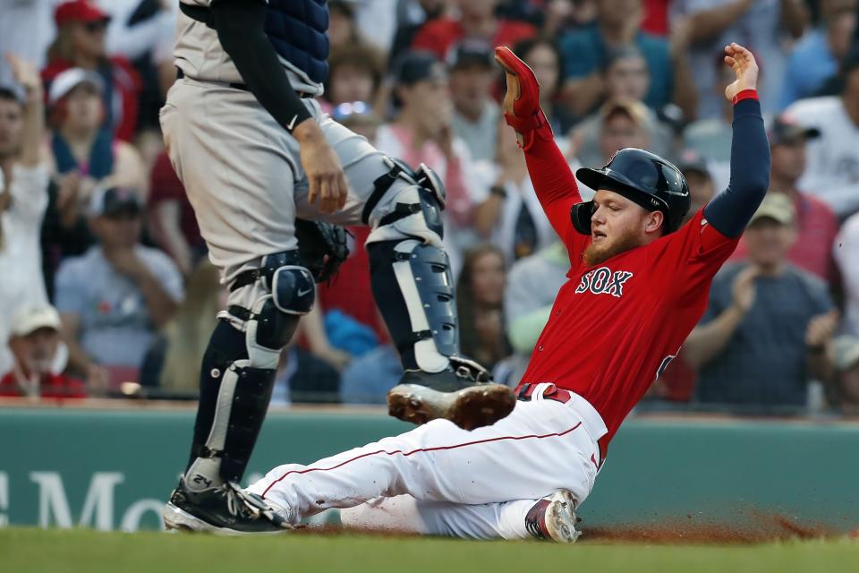 Boston Red Sox's Alex Verdugo, right, scores past New York Yankees' Gary Sanchez on a two-run double by Xander Bogaerts during the first inning of a baseball game, Friday, June 25, 2021, in Boston. (AP Photo/Michael Dwyer)