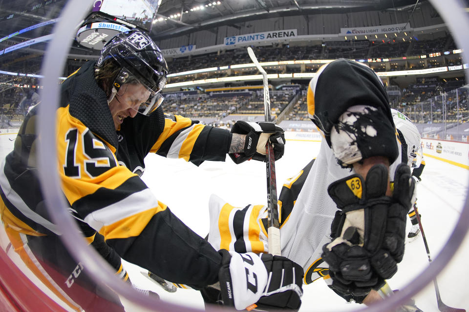 Pittsburgh Penguins' Jared McCann (19) checks Boston Bruins' Brad Marchand to the ice during the second period of an NHL hockey game in Pittsburgh, Tuesday, April 27, 2021.(AP Photo/Gene J. Puskar)