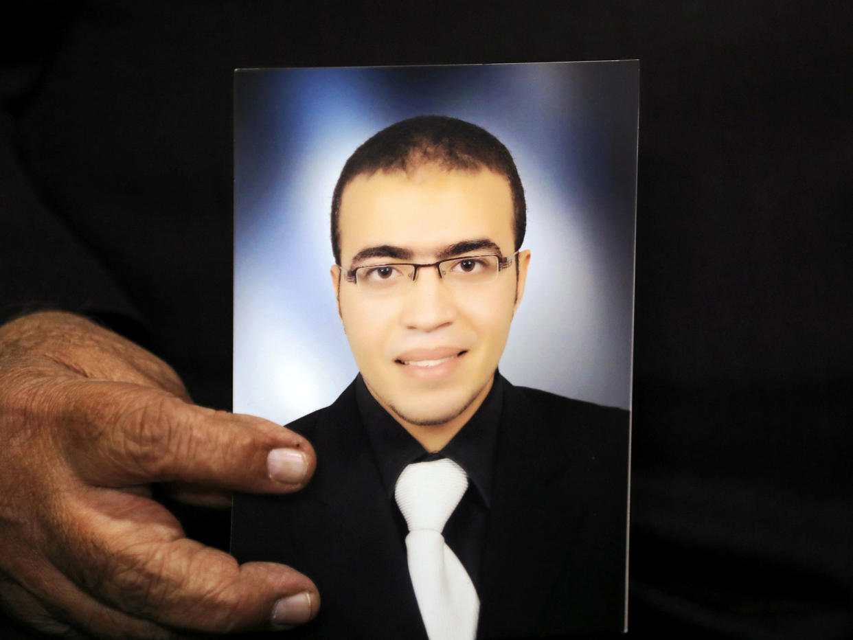 Reda Abdullah al-Hamamy, the father of Abdullah Reda al-Hamamy who is suspected of attacking a soldier in Paris' Louvre museum, holds a picture of his son in Egypt on 4 February: Reuters