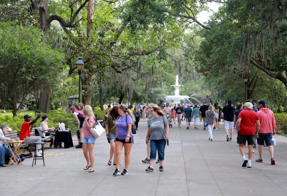 Visitors stroll through Forsyth park on a busy Saturday morning.