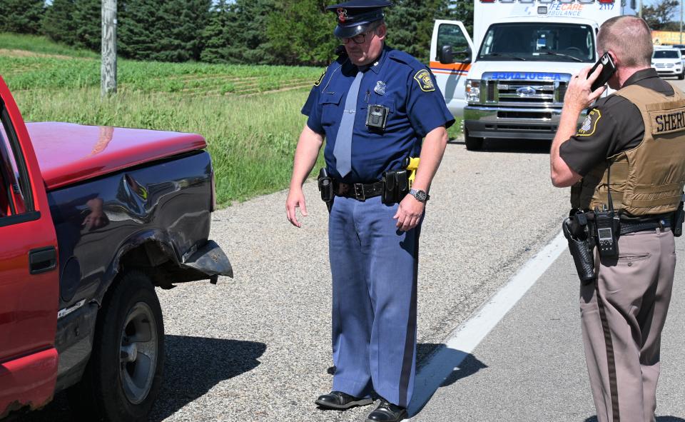 Michigan State Police trooper Alan Fouty and Branch County deputy Doug Pope examine the truck struck by the motorcycle ridden by a Detroit-area man on U.S. 12. Wind gusts of 26 mph may have contributed to the fatal crash.