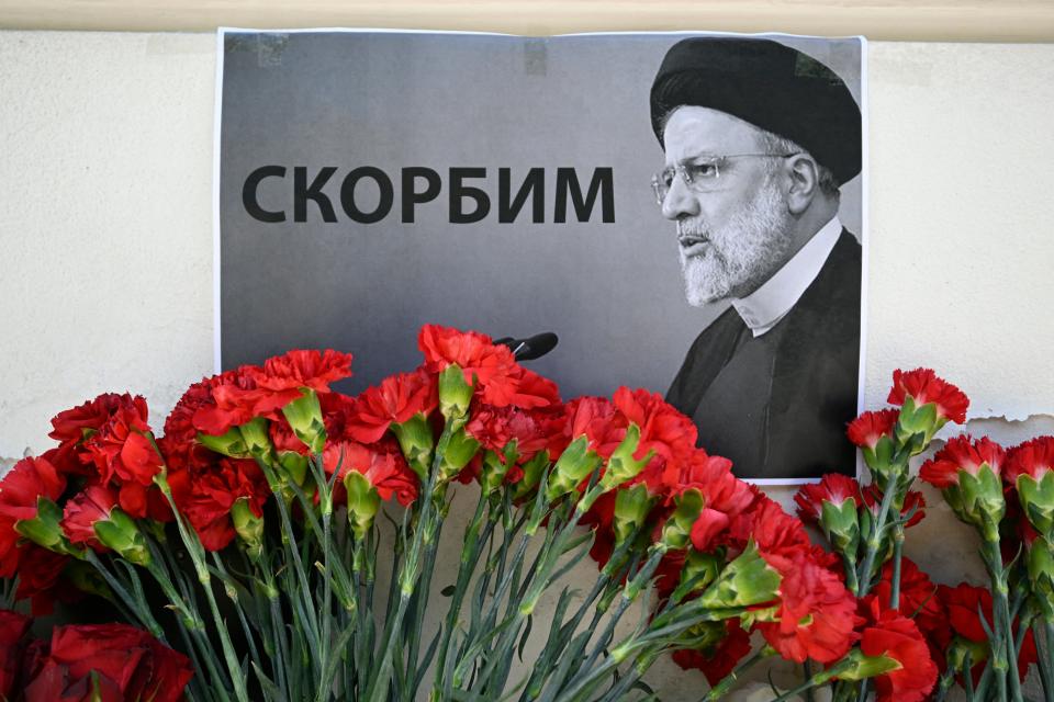 People bring flowers to the Iranian embassy to pay tribute to Iran's President Ebrahim Raisi and Foreign Minister Hossein Amir-Abdollahian, in Moscow (AFP via Getty Images)