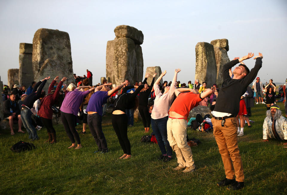 <p>People practice yoga by the stones of the Stonehenge monument at dawn on the summer solstice near Amesbury, Britain, June 21, 2017. (Photo: Neil Hall/Reuters) </p>