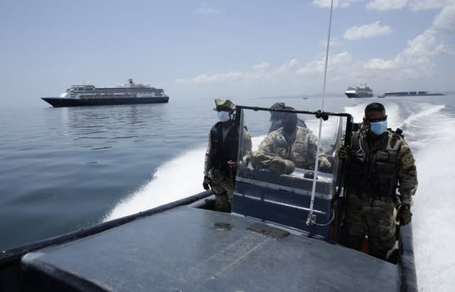 Panamanian navy police navigate near the anchored Zaandam cruise ship