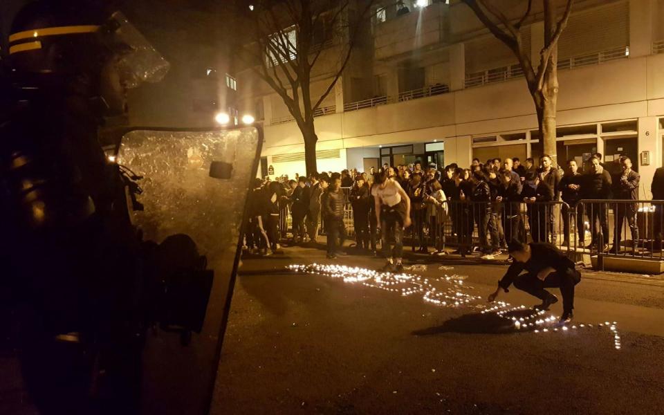 Youths use candles to write the word