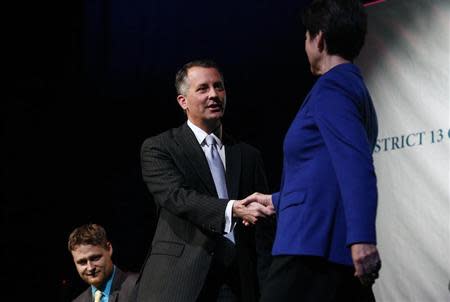 Democrat Alex Sink (C) and Republican David Jolly, both candidates for Florida's congressional District 13, shake hands before participating in a candidate forum which included Libertarian Lucas Overby (L) in Clearwater, Florida, February 25, 2014. REUTERS/Brian Blanco