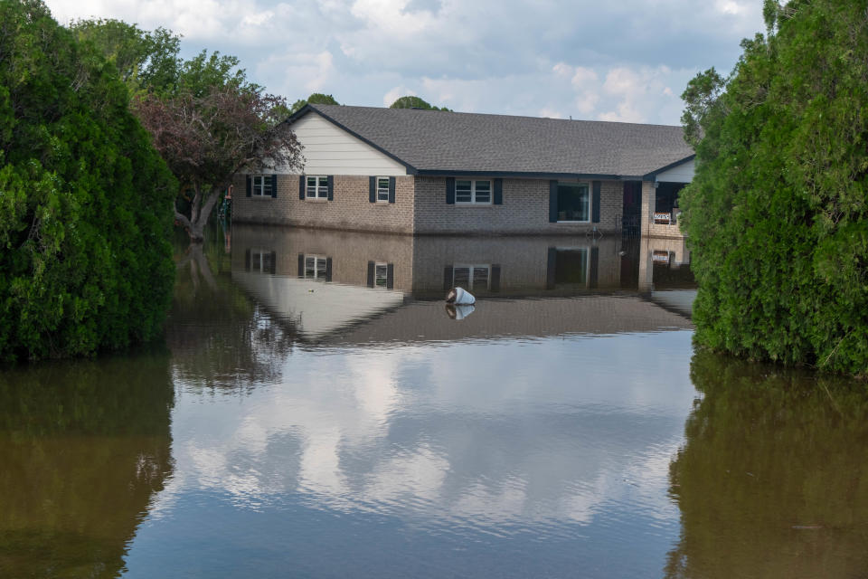 A flooded house Monday on 77th Street near Amarillo across from Greenways.