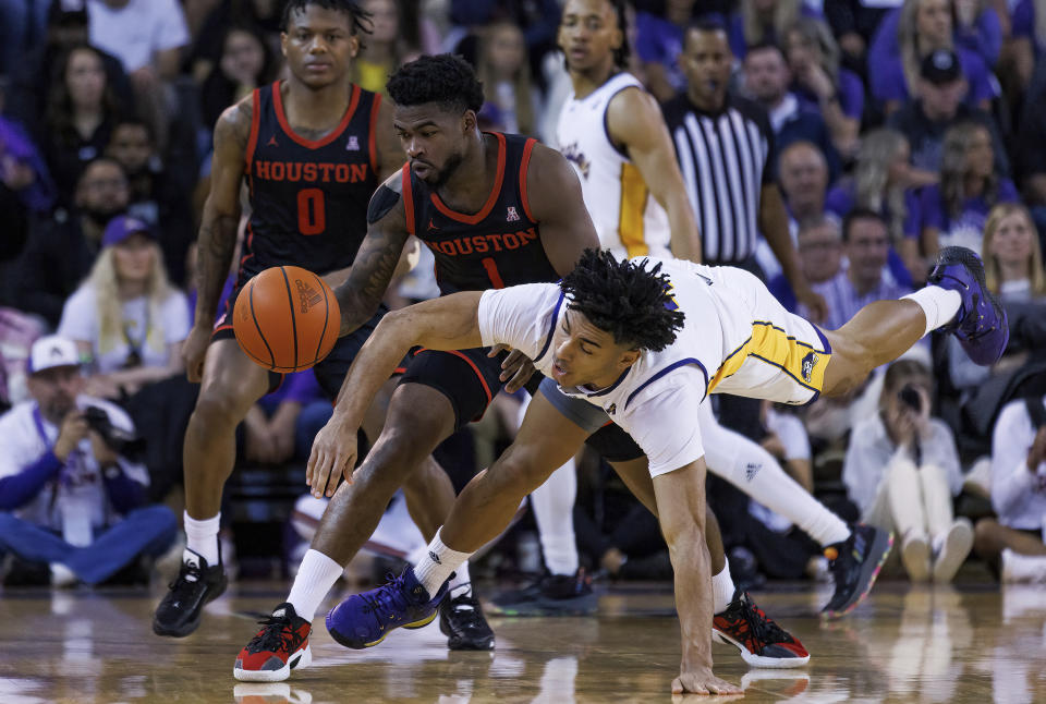 East Carolina's Quentin Diboundje, right, dives for the ball against Houston's Jamal Shead (1) during the second half of an NCAA college basketball game in Greenville, N.C., Saturday, Feb. 25, 2023. (AP Photo/Ben McKeown)