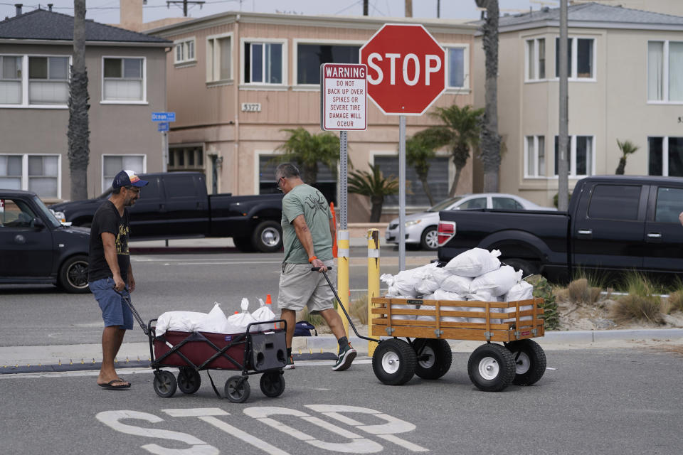 Long Beach residents pull wagons with sandbags ahead of Hurricane Hilary in Long Beach, Calif., Saturday, Aug. 19, 2023. Hurricane Hilary roared toward Mexico’s Baja California peninsula late Saturday as a downgraded but still dangerous Category 2 hurricane that's likely to bring “catastrophic” flooding to the region and cross into the southwest U.S. as a tropical storm. (AP Photo/Damian Dovarganes)