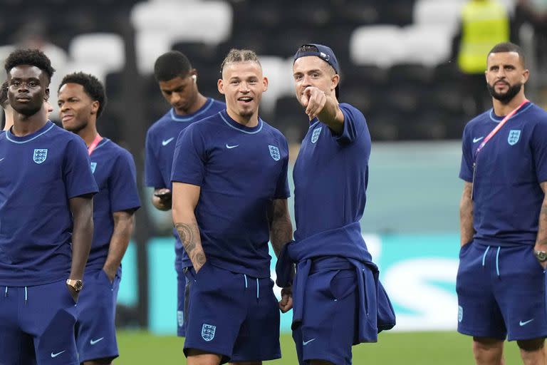 England's Kalvin Phillips, center left, and Jack Grealish have a chat on the pitch ahead of the World Cup group B soccer match between England and The United States, at the Al Bayt Stadium in Al Khor , Qatar, Friday, Nov. 25, 2022. (AP Photo/Luca Bruno)
