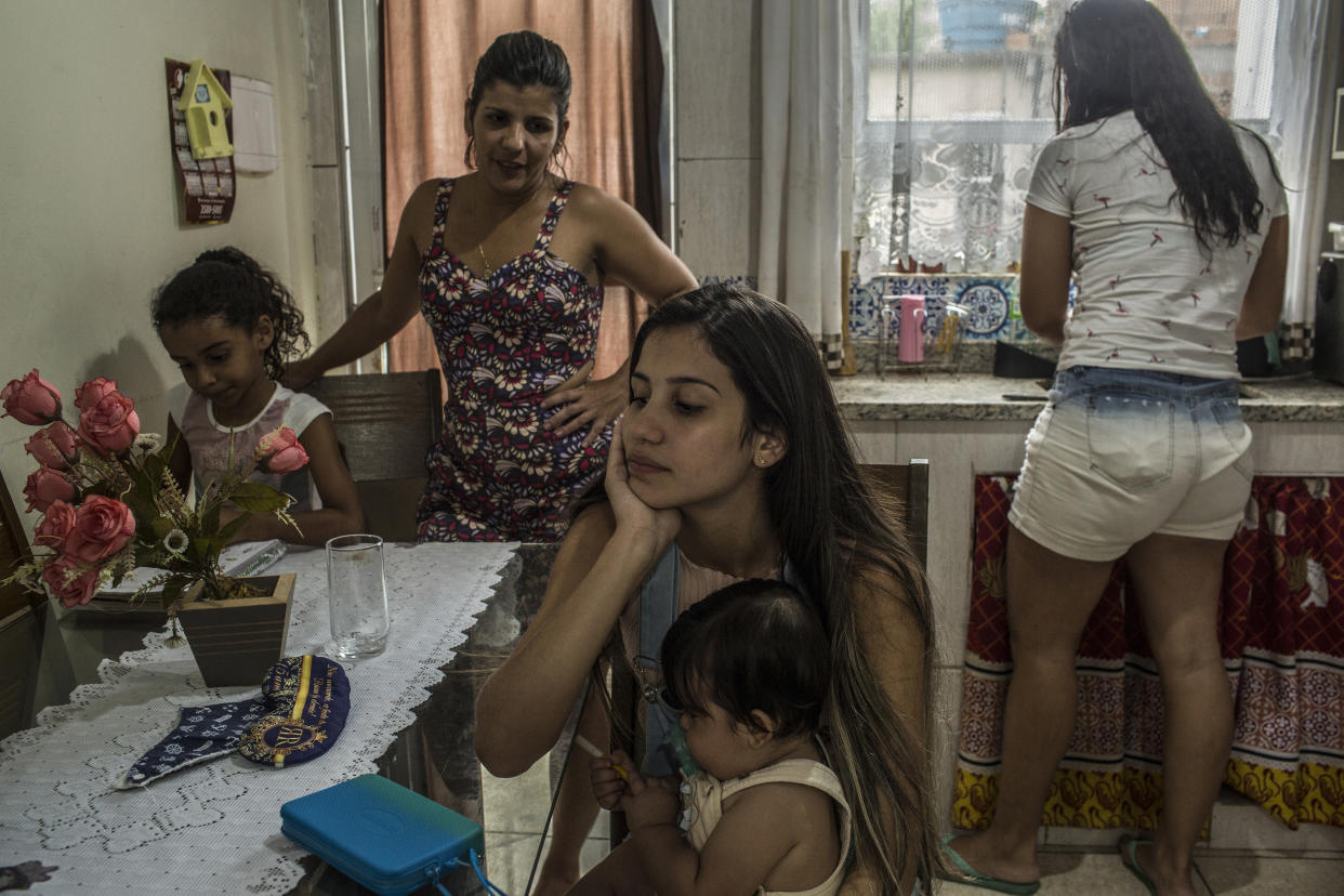 Laryssa Pereira de Souza, de 15 años, al centro, carga a su hijo de siete meses, Arthur Bernardo, en casa de su abuela en Río de Janeiro, el 19 de enero de 2020. (Dado Galdieri/The New York Times)