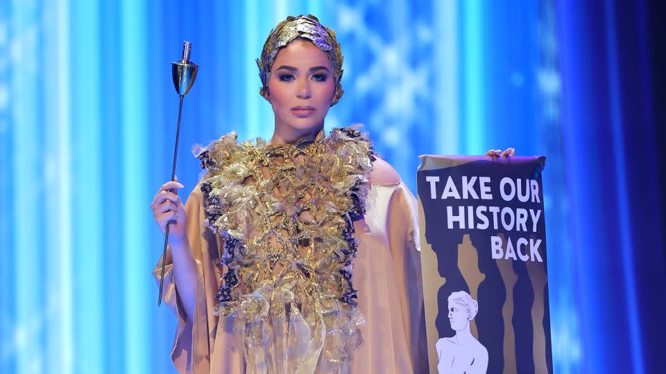 Miss Greece's draped ensemble — drawing from the clothes worn by ancient high priestesses — came with a placard that appeared to call for the repatriation of the country's artifacts from foreign museums. - Hector Vivas/Getty Images