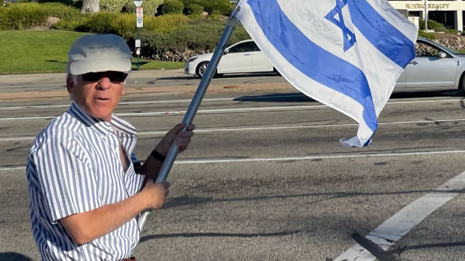 Paul Kessler holds an Israeli flag on November 5 at the intersection where the altercation would later take place. - Obtained by CNN