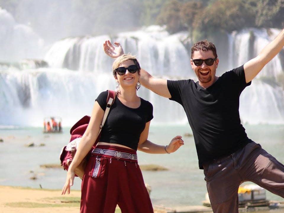 A woman and a man in front of a waterfall.