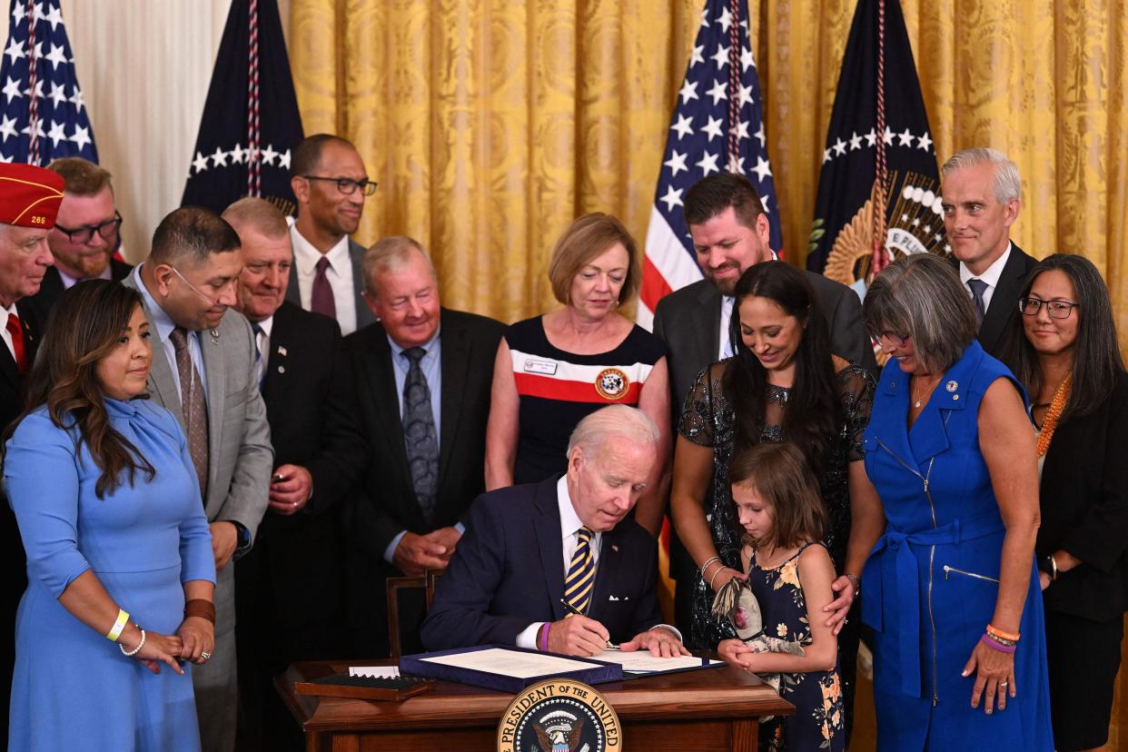 U.S. President Joe Biden (C) signs the PACT Act of 2022 into law during a ceremony in the East Room of the White House in Washington, DC on Aug. 10, 2022. The bill, officially titled the Sergeant First Class Heath Robinson Honoring our Promises to Address Comprehensive Toxics (PACT) Act of 2022, will help veterans who are suffering after being exposed to toxic burn pits during military service.