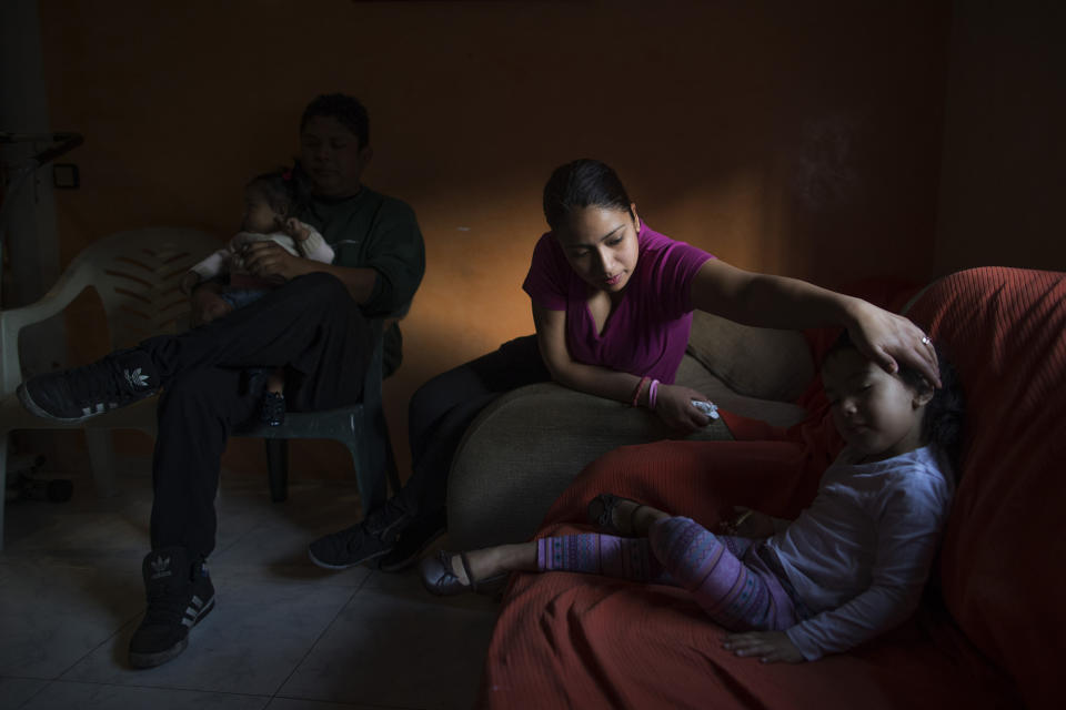 <p>Jimmy Chasi Sanguna holds his 1-year-old daughter, Daniela, while his wife Liseth Saavedra, 22 years old, caresses her 3-yea- old daughter, Dayana, as they wait for a judicial commission and the police to evict them, Madrid, April 11, 2014. (AP Photo/Andres Kudacki) </p>