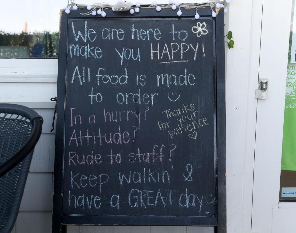 Sign in front of Turtle Beach Café says: “We are here to make you happy. All food is made to order. In a hurry? Attitude? Rude to staff? Keep walkin and have a GREAT day.” Thursday, June 17, 2021, on the Boardwalk in Bethany Beach, Delaware.