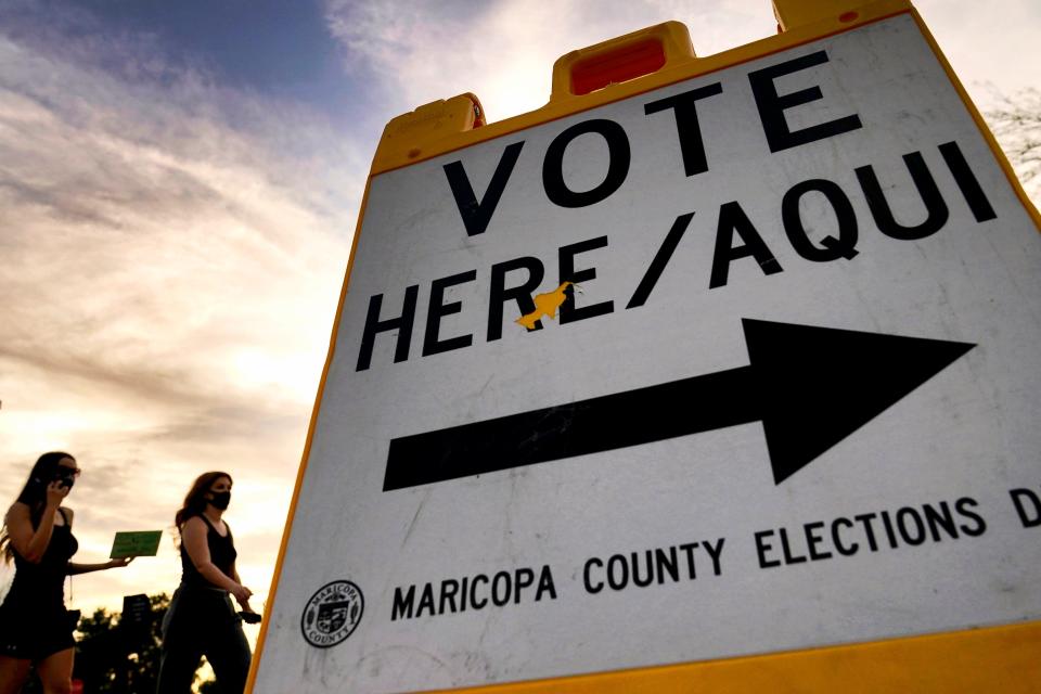 Voters deliver their ballot to a polling station in Tempe, Ariz., on Nov. 3, 2020.