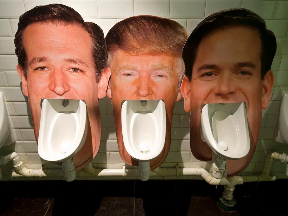 Cardboard cut outs of the faces of Ted Cruz, Donald Trump, and Marco Rubio, set up over urinals at a London pub during the 2016 presidential campaign.